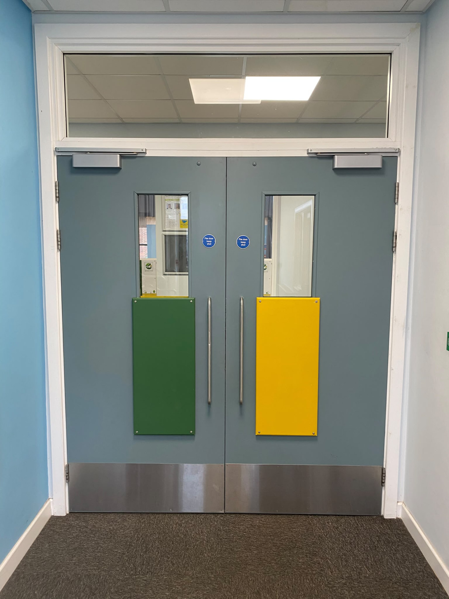 Double fire doors with coloured kick plates and overhead closers, Bridgeview